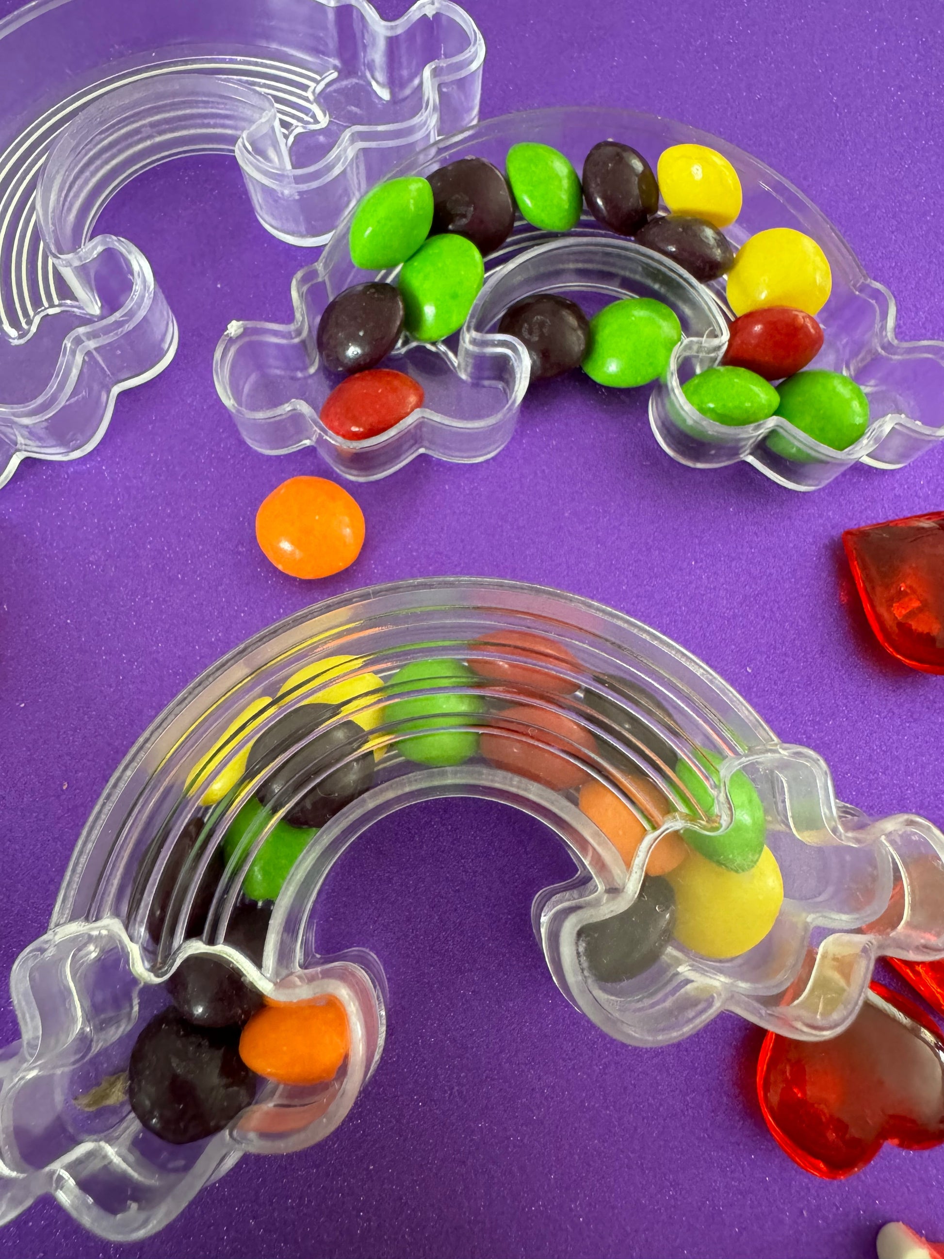 Trolls-themed birthday party favors featuring Poppy and Branch, enclosed in a rainbow-themed plastic box filled with Skittles. Perfect for celebrating and thanking guests, these candy favors are wrapped in cellophane with an optional thank you label. Great for playdates and available with other candy containers
