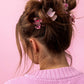 Set of 4 mini hair clips, each measuring 1.25 inches, ideal for stylish half-up hairstyles or adding a cute touch to any outfit. Includes 2 pink confetti clips and 2 pink acetate acid clips, presented on a 3.5" x 6.25" backer card with a gold ric rac ribbon hanger.