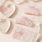 Pink hair clips with decorative elements on a beige surface