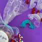 Rainbow sensory kit featuring handmade rainbow swirl glitter dough infused with confetti, miniature sensory charm mix, and soft glitter pompoms. Designed to engage senses and inspire creativity for toddlers and kids ages 3+. Promotes brain development, fine motor skills, and emotional growth. Includes small parts; parental supervision recommended.