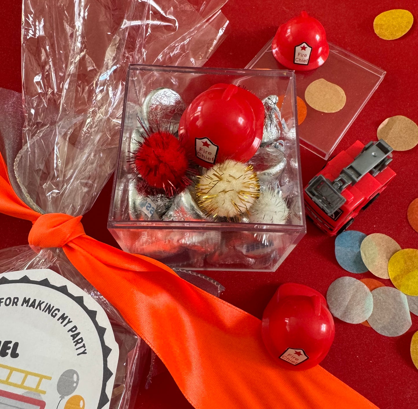 Delight in our Firetruck Themed candy favor, perfect for birthdays and firehouse play dates. This magical treat comes in a perfectly sized square plastic box filled with chocolate 'kisses' themed with firetruck labels. Each box is wrapped in cellophane and can include a thank you label. Explore more candy container options. Ideal for fire truck, firefighter, and tractor-themed parties, ensuring a delicious and fun addition to your celebration.