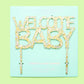 Handmade "Welcome Baby" cake toppers with confetti and sparkle, perfect for party decor.