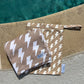 Two brown bags with white lightning bolt patterns on a concrete surface near a pool.