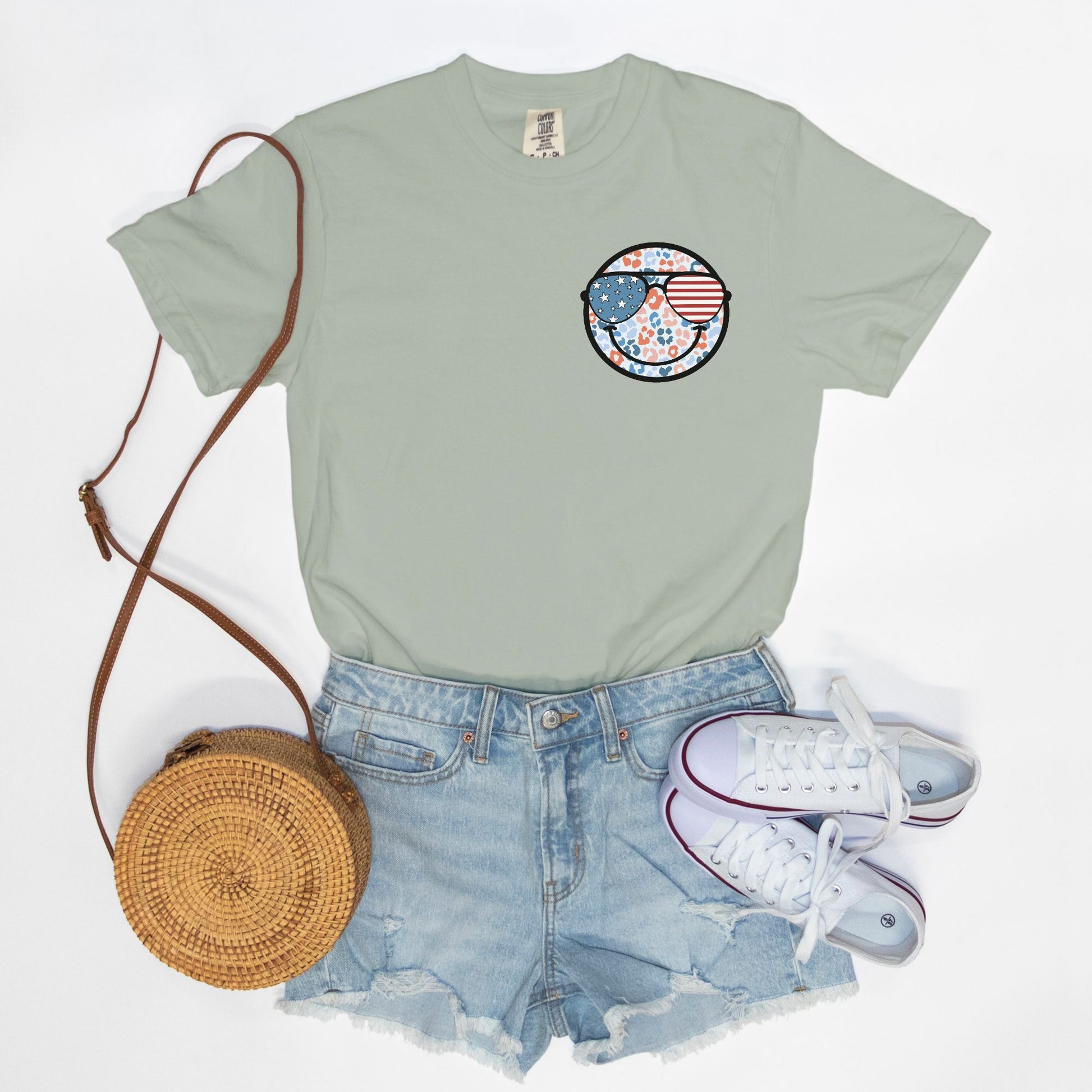 Retro smiley face sunglasses t-shirt featuring a patriotic design with American flag shades. Perfect for 4th of July celebrations, this vintage-style Comfort Colors tee is soft-washed, pre-shrunk, and available in unisex sizes. Show off 90s nostalgia with this fun and comfortable USA flag shirt, ideal for summer BBQs, fireworks, and family gatherings.