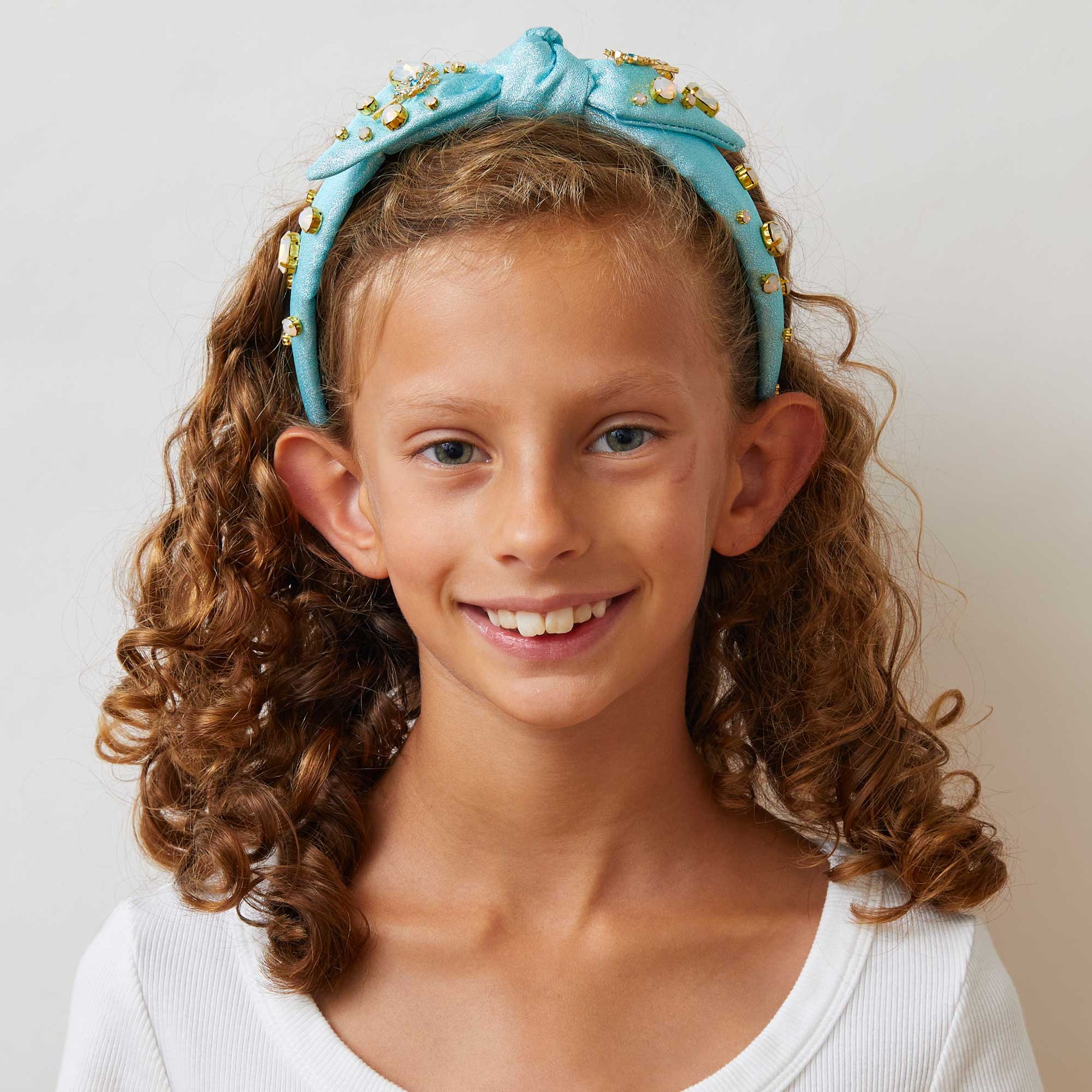 Lele Sadoughi x Wicked Headband, NY Broadway Collaboration, Wicked 25th Anniversary Accessories, Glinda-Inspired Magical Wand Design, Bubble Blue Poly Blend Headband, Hand-Embellished Oval Opals & Round Crystals, 14k Gold-Plated Wand Charms, Comfort Fit Band for Ages 3-9, Trademark Logo Charm, Spot Clean, Custom Collaboration Pouch Included, Stylish & Comfortable NYC Design, High-Quality Fabrics & Hand-Sewn Trims, Iconic Wicked Accessories, Perfect Gift for Broadway Fans, Unique Collaboration Headband, Lele