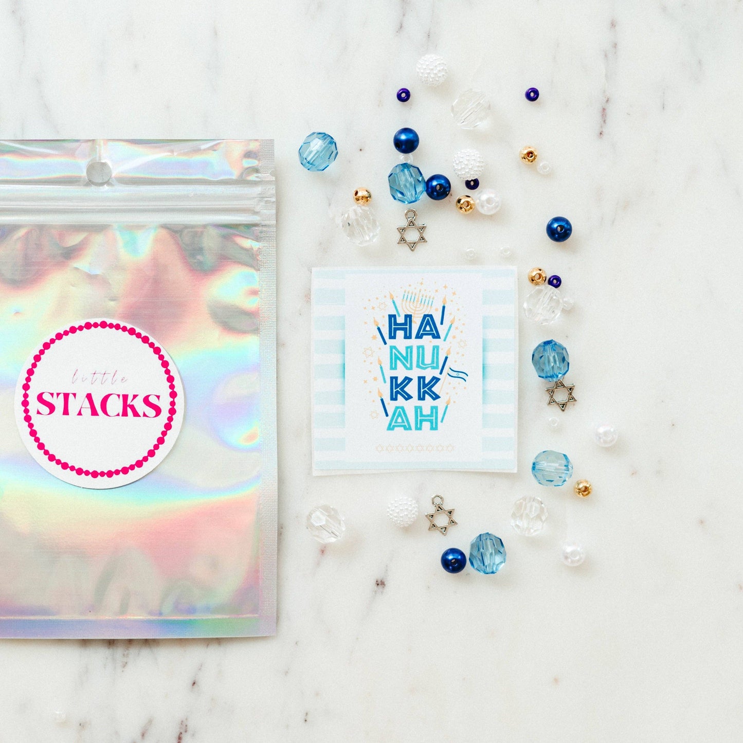 Create a festive Hanukkah stack with this bracelet kit featuring Star of David charms, pearls, and colorful beads. Makes 2+ bracelets (10-year-old sizing). WARNING: Small parts, choking hazard for children under 3. Adult supervision recommended.