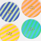 Bold striped birthday plates with gold foil 'Happy Birthday' text, pack of 8, 4 color combos.