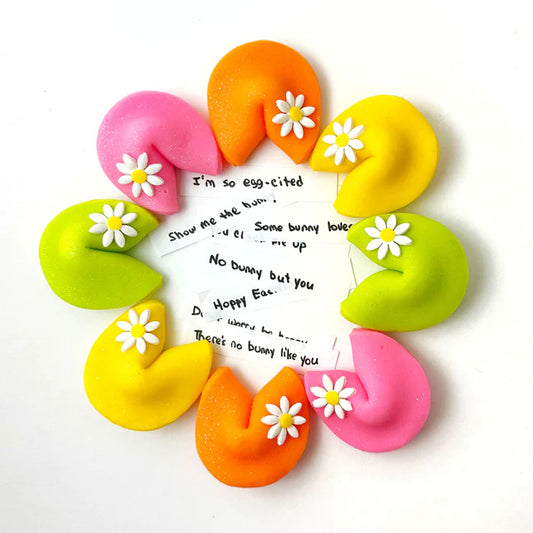 Easter marzipan fortune cookies with fun sayings inside, topped with daisies and glitter.